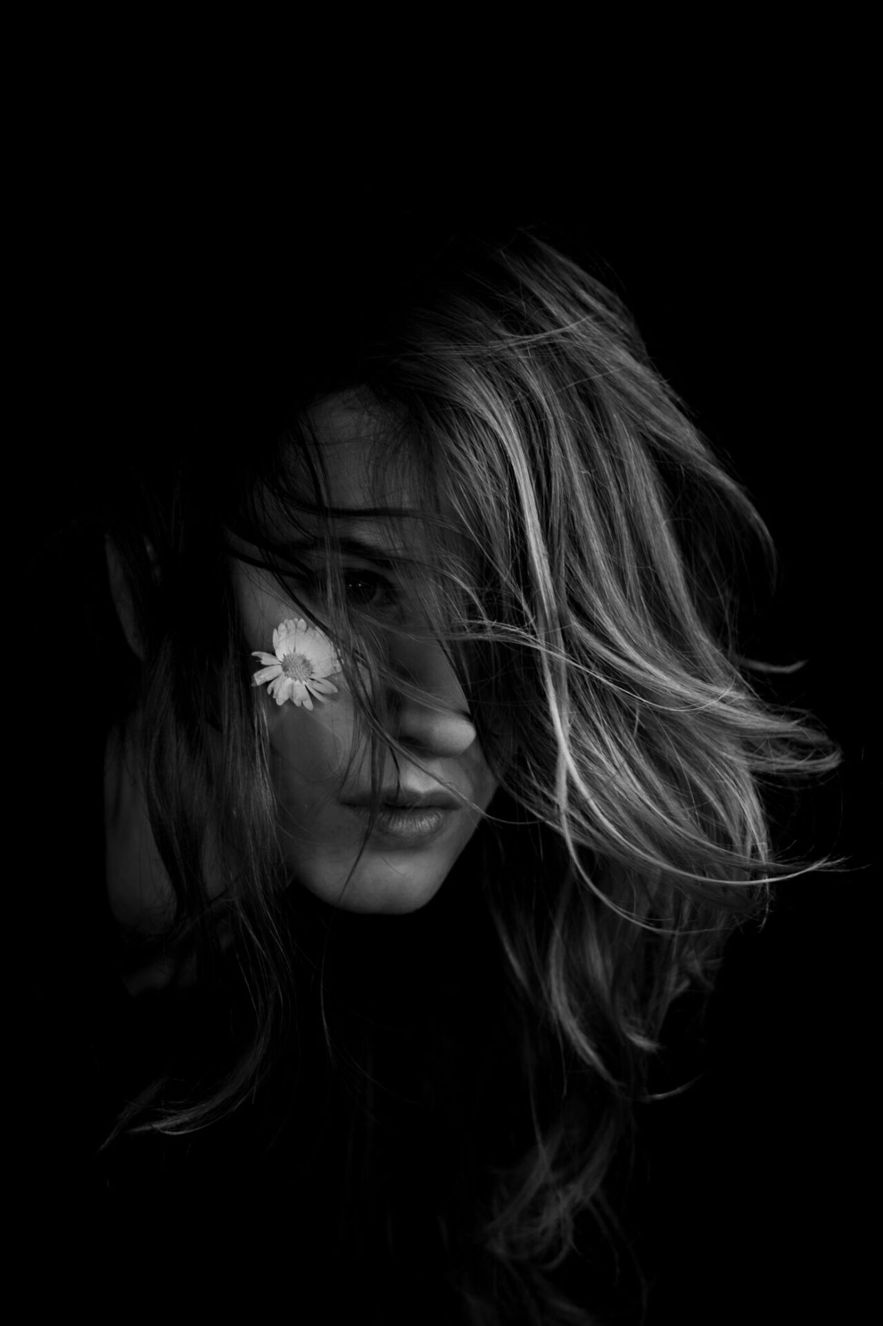 black and white photo of a young woman with a flower